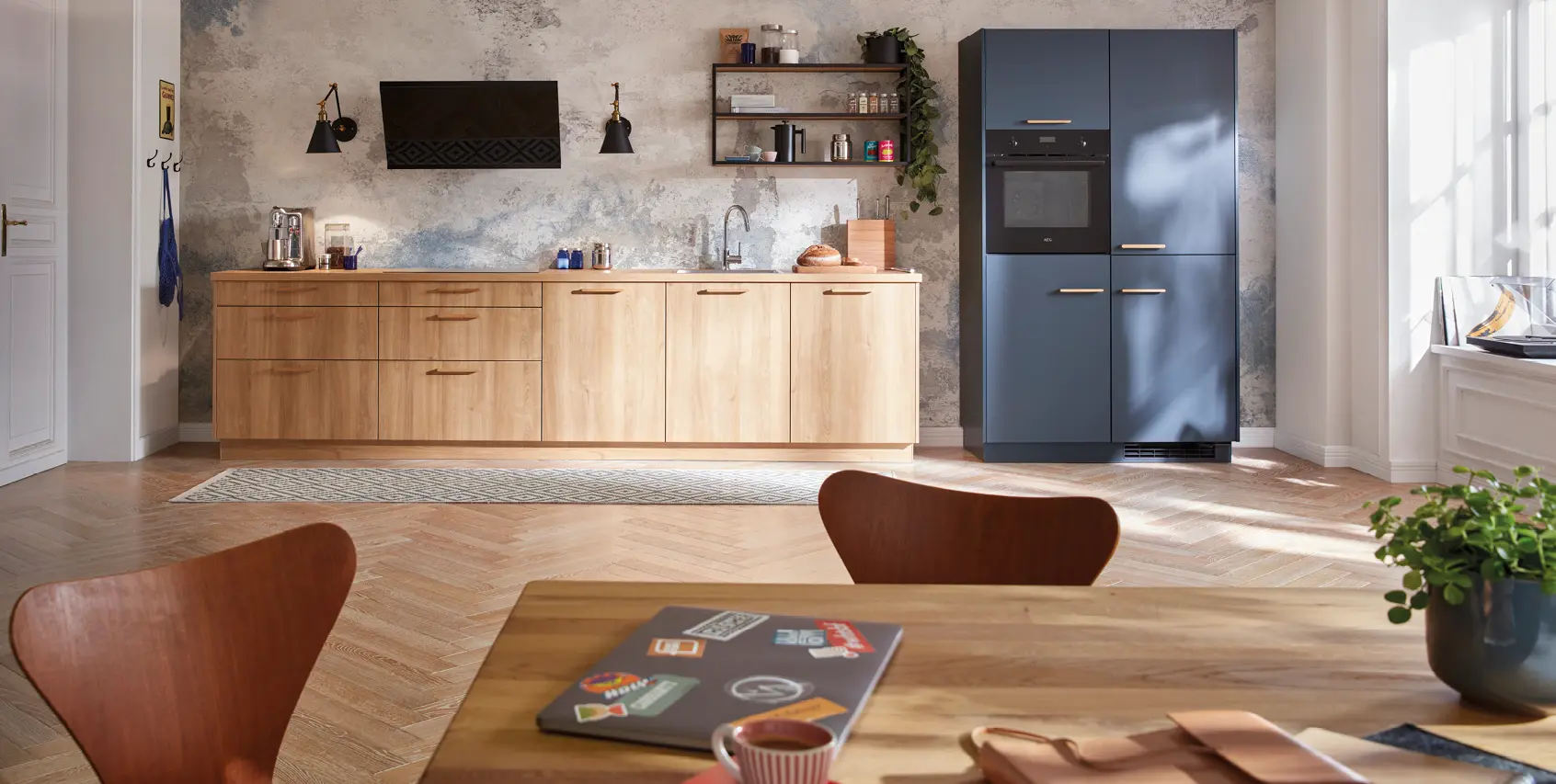 Moderne Einbauküche mit Holzfronten, offenen Regalen und blauen Hochschränken mit Backofen. Küchenzeile im zeitlosen Design mit stilvoller Wandgestaltung, Licht und viel Stauraum für modernes Wohnen.